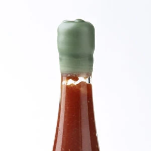 Bottle containing tomato sauce, sealed with green wax