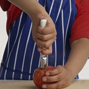 Child pushing corer into apple to remove the core