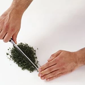 Chopping parsley with a knife, close-up