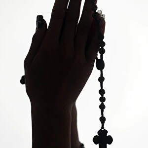 Christian woman praying the Rosary. Close-up. Vietnam
