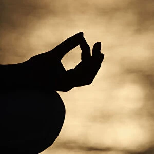 Close up hand of young of woman practice meditation in lotus position. Yoga at sunset