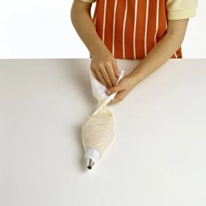 Cook twisting top of piping bag, pastry filling bag
