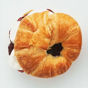 Croissant filled with whipped cream and jam