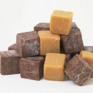 Fudge, toffee- and chocolate-coloured cubes in heap, front view