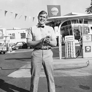 Gas station attendant standing in front of station
