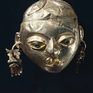 A gold-leaf female head with turquoise, nariquera (nose ring) and pendent from La Tolita, Ecuador