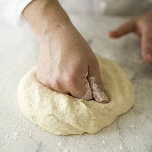 Hand kneading pizza dough, close-up
