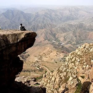 Man sitting on a rock in Halmlam, Halmlam, Yemen
