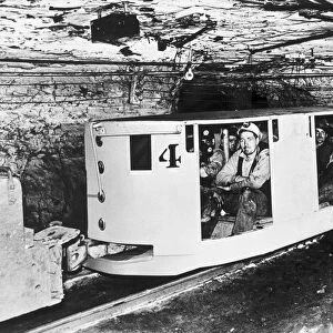 Miners in underground coal train cars