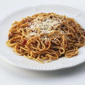 Plate of spaghetti bolognese sprinkled with grated cheese