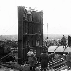 Post-war donbass heals its wounds, setting up a cylindrical head-frame, designed by engineer zherbin, at the dzerzhinsky colliery no, 12 in donbass, ussr, 1940s