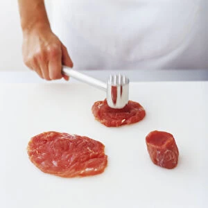 Pounding pieces of red meat into a flat shape