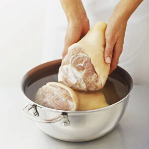 Putting ham hocks in a saucepan filled with cold water