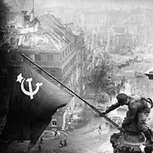 Red army soldiers raising the soviet flag over the reichstag in berlin, germany, april 30, 1945, photo taken by vladimir grebnev