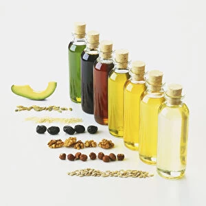 Row bottles, with cork stoppers, containing avocado, pumpkin, sesame, olive, walnut, hazelnut, and sunflower oils