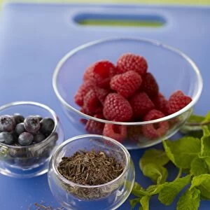 Small bowls of raspberries, grated chocolate and blueberries