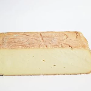 Square of Italian Taleggio PDO cows milk cheese showing mould-ripened rind and soft interior