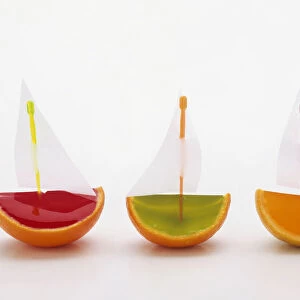 Strawberry, lime, and orange jelly boats with paper sails made from orange skins and cocktail sticks