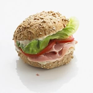 Wholemeal bun stuffed with mayonnaise, ham, tomato slices and lettuce