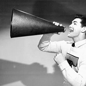 Young man shouting into megaphone, 1950s-60s black and white