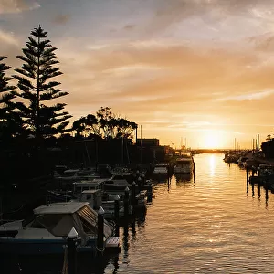 Boats anchored along Mordialloc creek during a beautiful sunset in Melbourne