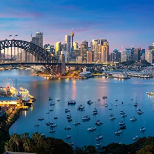 Cityscape image of Sydney, Australia with Harbor Bridge and Sydney skyline during sunset