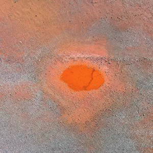 Drone image looking down on a circular shaped pool of water in an iron mine, Western Australia, Australia
