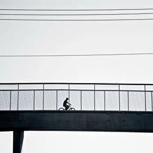 Cyclist crossing bridge