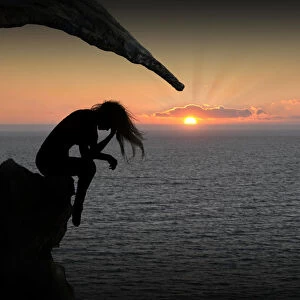 Dramatic silhouette woman on sunset ocean