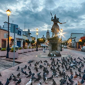 Ecuestre del ApAostol Santiago el Mayor statue, with many pigeons around it, in Queretaro, Mexico at dawn
