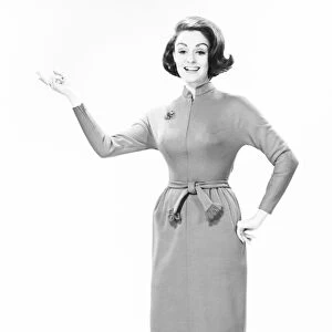 Elegant woman standing in studio, gesturing, (B&W), portrait