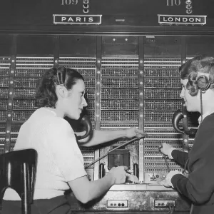 Two female switchboard operators connecting international calls (B&W)