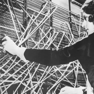 Female telephone switchboard operator connecting caller, close-up (B&W)