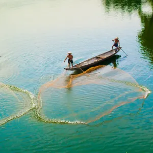 Fishermen catch fish in the river in Hue, Vietnam