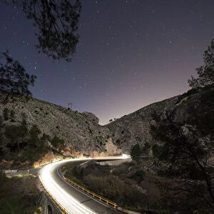 Lights of vehicles circulating along a road with curves during the night