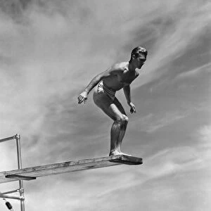 Man standing on springboard, preparing to dive, (B&W)