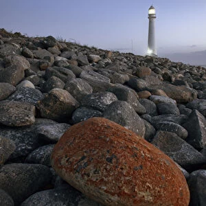 The Odd One Out, a single rock stands out of the landscape at the Kommetjie Lighthouse in Cape Town, Western Cape Province, South Africa