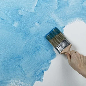 Person painting glaze onto wall with brush