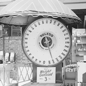 Weighing scale at amusement park, (B&W)
