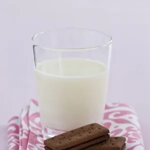 Bedtime snack of a glass of cold fresh milk with bourbon chocolate biscuits credit