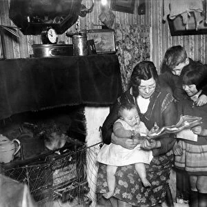Living conditions in the slums of the East End. Mrs Livesey with her baby and two