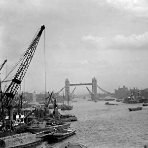 London. River Thames with barges, boats and crane with the Tower Bridge in the