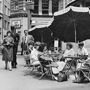 Office girls take their lunch break al fresco in a continental style table and umbrella