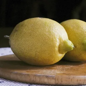 Two whole yellow lemons from Majorca on wooden board credit: Marie-Louise Avery