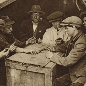 Bargee and his mates playing dominoes in the hold of a barge on a London canal (b / w photo)
