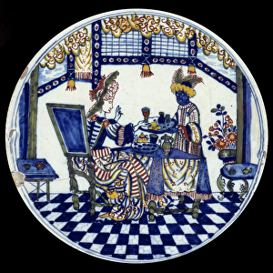 Delft porcelain plate representing a woman at a table served by her black servant