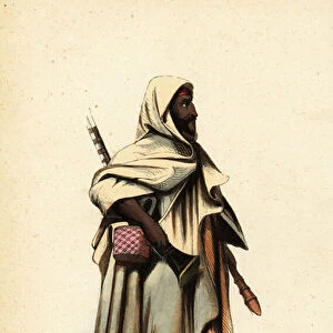Nomadic Bedouin or Bedu man of Kordofan (Sudan) in hooded burnous, carrying a musket and square case