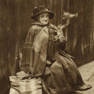 Old woman drinking tea on the street (b / w photo)