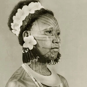 Solomon islander adorned with tattoos, a shell torque and frangipani (photo)