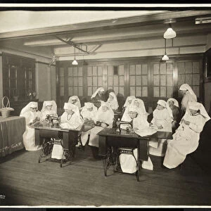 Women wearing white smocks, in a sewing class, presumably during or associated with World